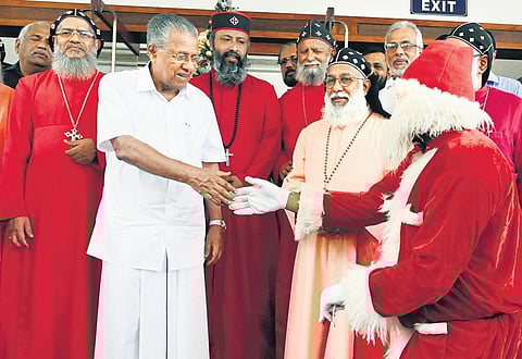 Chief Minister Pinarayi Vijayan greeting a man dressed up as Santa Claus after the Christmas and New Year lunch for bishops of various churches in Thiruvananthapuram on Wednesday. Archbishop Baselios