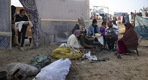 Members of the Abu Jarad family, who were displaced by the Israeli bombardment of the Gaza Strip, bake bread at a makeshift tent camp in the Muwasi area, southern Gaza. (Photo | AP)