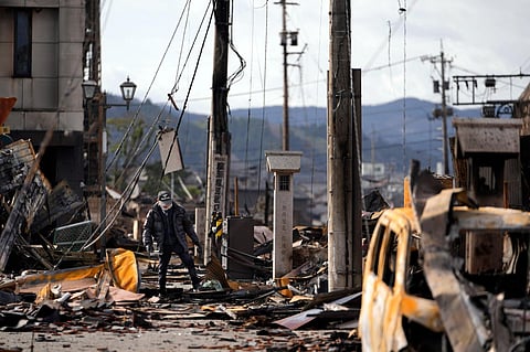 A man walks through debris after a fire at a shopping area in Wajima in the Noto peninsula, facing the Sea of Japan, following Monday's deadly earthquake. (Photo | AP)