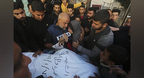 Al Jazeera journalist Wael Dahdouh holds the hand of his son Hamza, who also worked for Al Jazeera and who was killed in an Israeli airstrike in Rafah, Gaza Strip. (Photo | AP)