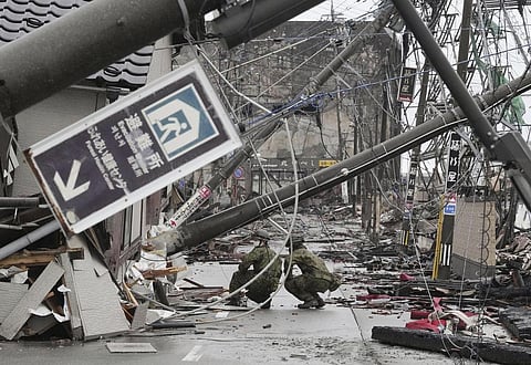 Members of Japan Self-Defense Forces call around to see if people are trapped in a destroyed house during a search operation in Wajima, Ishikawa prefecture, Japan. (Photo | AP)