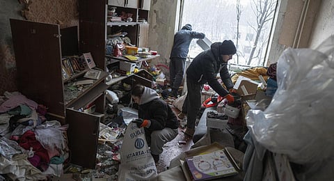 Volunteers clear the rubble inside an apartment of a residential building which was heavily damaged yesterday by Russian attack in Kyiv, Ukraine. (Photo | AP)