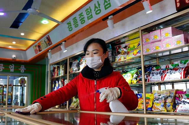 An employee of the Kyonghung Foodstuff General Store disinfects the showroom countertops in Pyongyang. (Photo | AP)