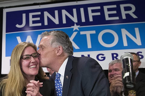 Democrat Jennifer Wexton (L) smiles as former Virginia Gov. Terry McAuliffe gives her a kiss at her election night party after defeating Republican Barbara Comstock (Photo | AP)