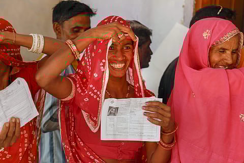 A voter smiles as she shows identity card during the Rajasthan Assembly elections at a polling station in Ajmer on 7 December 2018. (Photo | PTI)
