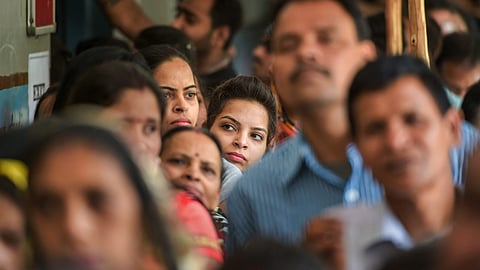 Voters wait in queues to cast their votes.