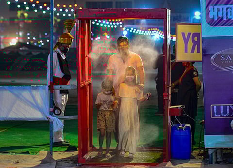 People get sanitised as they enter Ramleela ground during Dussehra Festival. (Photo| PTI)