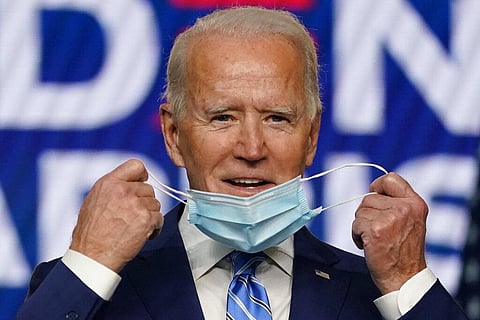 Democratic presidential candidate former Vice President Joe Biden takes off his face mask as he arrives to speak in Delaware. (Photo | AP)