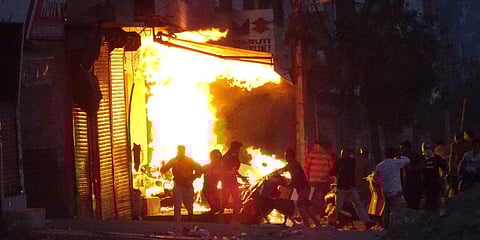 A shop burns as a mob sets it on fire during violence in New Delhi. (Photo | AP)