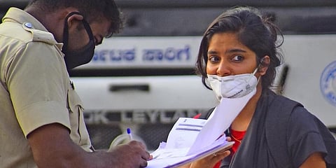 Police noting down details of a Mangaluru-returnee at the Majestic Bus Terminus in Bengaluru. (Photo | EPS)