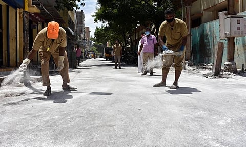 Corporation workers spread disinfectant powder to keep Coronavirus away at Chetti Street in Coimbatore on Tuesday. (Photo | U Rakesh Kumar, EPS)