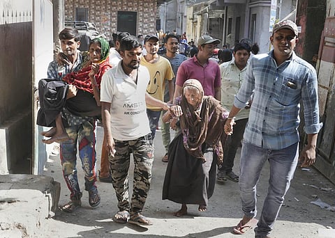 Elderly voters being helped as they arrive to cast their votes at a polling station during the first phase of Gujarat Assembly elections, in Gir Somnath district. (Photo | PTI)