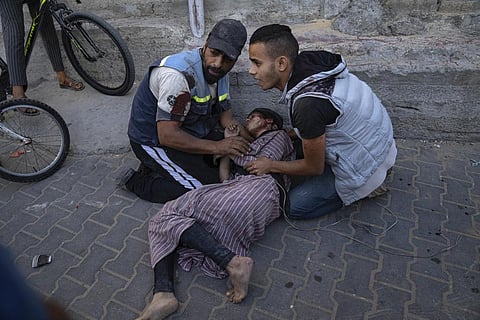 Palestinians tend to an injured girl after an airstrike in Khan Younis, Gaza Strip, Saturday, Oct. 21, 2023. (AP)