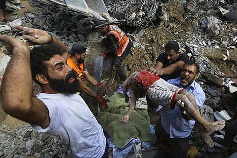 Palestinians carry the body of a dead child who was found under the rubble of a destroyed house after Israeli airstrikes on Gaza City, Tuesday, Oct. 24, 2023. (Photo | AP)