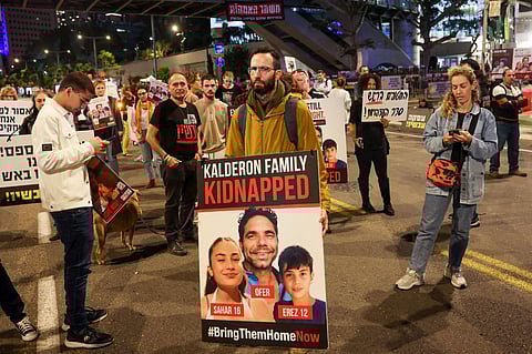 Families of Israeli hostages held by Palestinian militants in the Gaza Strip protest outside the ministry of defence in Tel Aviv calling for their release, on November 21, 2023. (AFP)