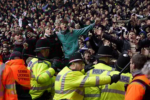 Fans invading the pitch clash with police officers, during the English FA Cup fourth round soccer match between West Bromwich Albion and Wolverhampton Wanderers.