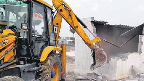 A bulldozer demolishes a house
in Kapra on Saturday
