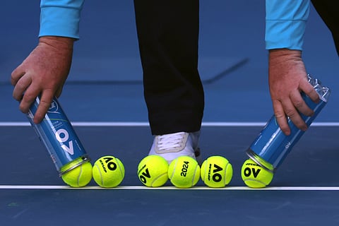 A court official lays out new balls for a first round match at the Australian Open
