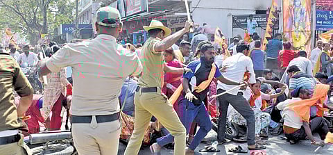 Police cane protesting BJP and JDS workers in Mandya on Monday.