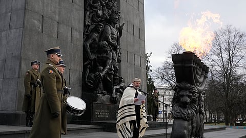 A rabbi say prayers on the eve of the 79th anniversary of the liberation of the Nazi German death camp of Auschwitz-Birkenau by Soviet troops , at the Monument to the Heroes of the Ghetto, in Warsaw, Poland, Friday Jan. 26, 2024.