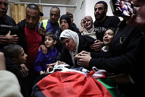 Relatives mourn over the body of one of the Palestinians, who were killed during a days-long Israeli raid, during their funeral in a refugee camp in Tulkarm in the occupied West Bank on January 19, 2024 amid ongoing battles between Israel and the Palestinian militant group Hamas in Gaza.