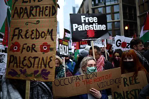 Pro-Palestinian activists and supporters wave flags and carry placards during a National March for Palestine in central London on January 13, 2024.