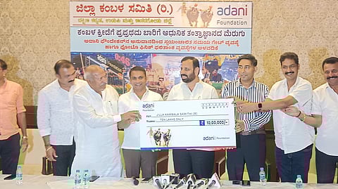 Kishore Alva, Executive Director of Adani Group, handing over a cheque of Rs 10 lakh to Deviprasad Shetty Belapu, president of Zilla Kambala Samithi.