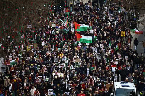 Pro-Palestinian activists and supporters wave flags and carry placards during a National March for Palestine in central London on January 13, 2024.