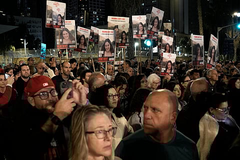 People hold signs showing a picture of a hostage during a demonstration calling for the release of the hostages taken by Hamas militants to Gaza during the Oct. 7th attack, during a demonstration in Tel Aviv, Israel, Saturday Jan. 20, 2024.