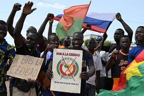A small group of protesters hold Russian and Burkina Faso flags as they protest against the Economic Community of West African States (ECOWAS), whose representatives are expected today in Ouagadougou on October 4, 2022.