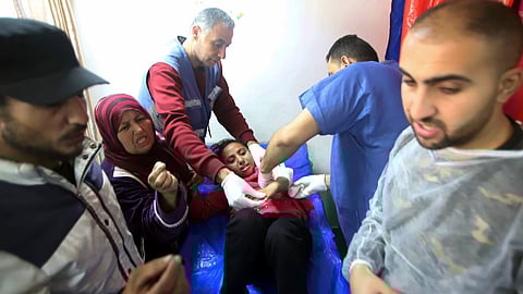 Palestinian medics treat a girl wounded in the Israeli bombardment at a building of an UNRWA vocational training center which displaced people use as a shelter in Khan Younis, southern Gaza Strip, on Jan. 24, 2024.