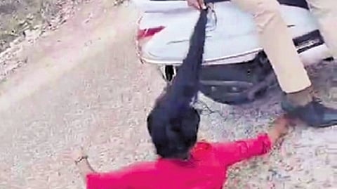 A videograb showing the protestor being dragged by cops on a two-wheeler.