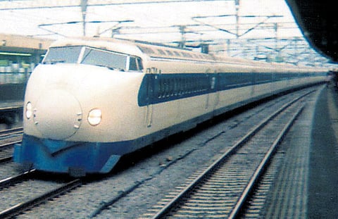 The first Shinkansen zips through a Tokyo station in this vintage photograph