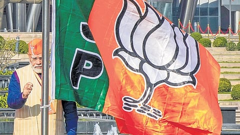 Prime Minister Narendra Modi hoists BJP’s flag during the BJP National Council meeting in New Delhi on Saturday, Feb 17, 2024.