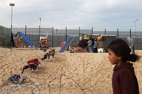 Displaced Palestinians camp near the border fence between Gaza and Egypt.