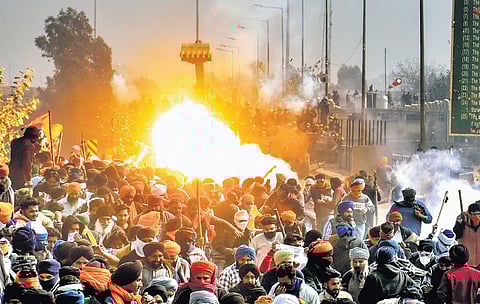Protesters run for cover as a tear gas canister fired by Haryana police explodes near the Shambhu border point between Punjab and Haryana on Wednesday.