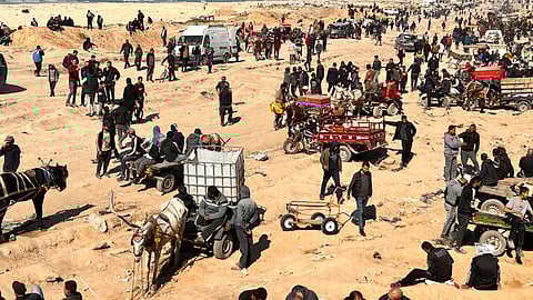 Palestinians wait for humanitarian aid on a beachfront in Gaza City, Gaza Strip.