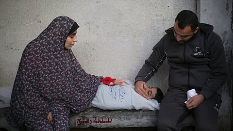 Palestinians mourn a child killed in the Israeli bombardment of the Gaza Strip at a hospital morgue in Rafah, Monday, Feb. 12, 2024.