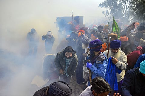 Patiala: Farmers look for cover after police fired tear gas at them during their 'Delhi Chalo' march, near the Punjab-Haryana Shambhu border, in Patiala district, Wednesday, Feb. 21, 2024.