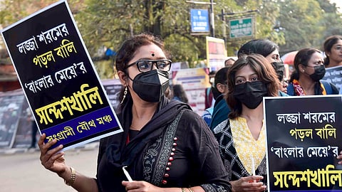 Members of Sangrami Joutha Mancha hold placards during a protest against Sandeshkhali case, in Kolkata.
