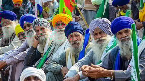Farmers listen to a leader (unseen) at the Punjab-Haryana Shambhu border during farmers' 'Delhi Chalo' protest, near Patiala district, Saturday, Feb. 17, 2024.