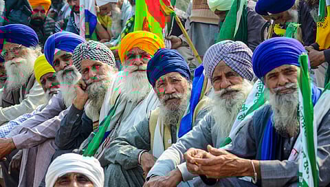 Farmers listen to a leader (unseen) at the Punjab-Haryana Shambhu border during farmers' 'Delhi Chalo' protest, near Patiala district, Saturday, Feb. 17, 2024.