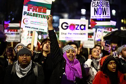 Pro-Palestinian demonstrators wave Palestinian flags and hold placards as they protest in Parliament Square in London on February 21, 2024, during an Opposition Day motion in the the House of Commons calling for an immediate ceasefire in Gaza.
