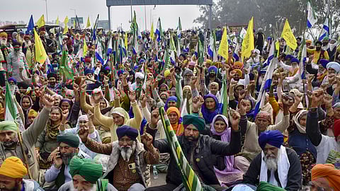 Farmers listen to a leader at the Punjab-Haryana Shambhu border during their 'Delhi Chalo' protest, near Patiala district.