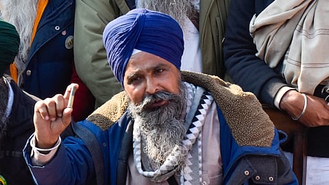 Farmer leader Sarwan Singh Pandher shows tear gas shells used by the paramilitary force on farmers at a press briefing.