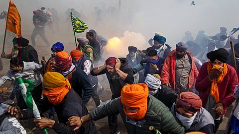 Protesting farmers run away from exploding tear gas shells used by the police near Shambhu border that divides Punjab and Haryana, Wednesday, February 21, 2024.
