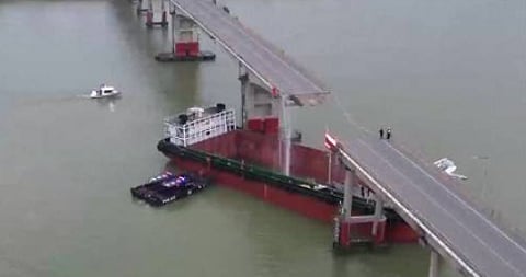 The boat "came into contact with... the bridge pillars, causing the roadway above to collapse", CCTV reported.