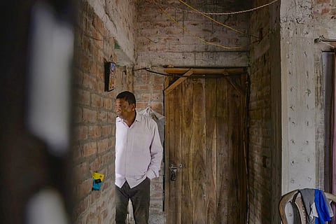 Local TMC leader Ajit Maity takes shelter inside a house after he was allegedly chased by villagers at Sandeshkhali, in North 24 Parganas district, Sunday, Feb. 25, 2024.