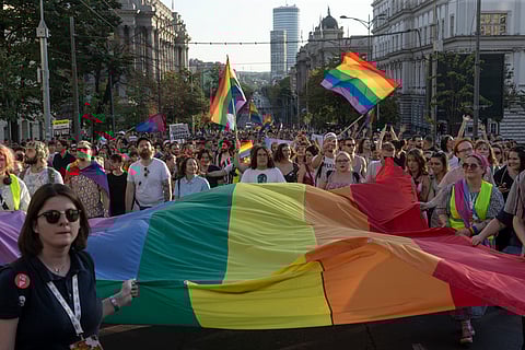 People hold a large Rainbow flag as they take part in a Pride march in Belgrade, Serbia, Saturday, Sept. 9, 2023.