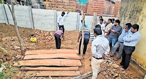 The well dug by Gowri Naik is being closed by workers.